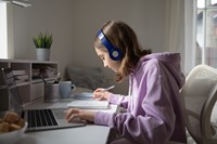 Image of student wearing headphones and studying with laptop